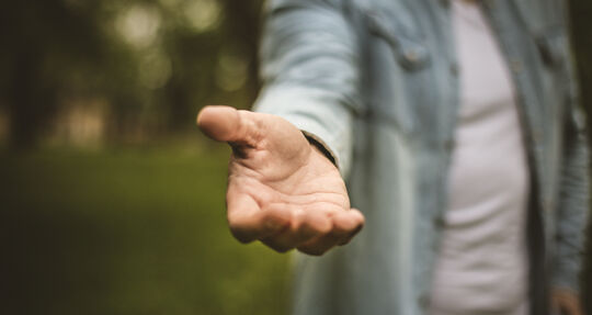 ein Mann streckt seine Hand aus | GettyImages / Mladen Zivkovic